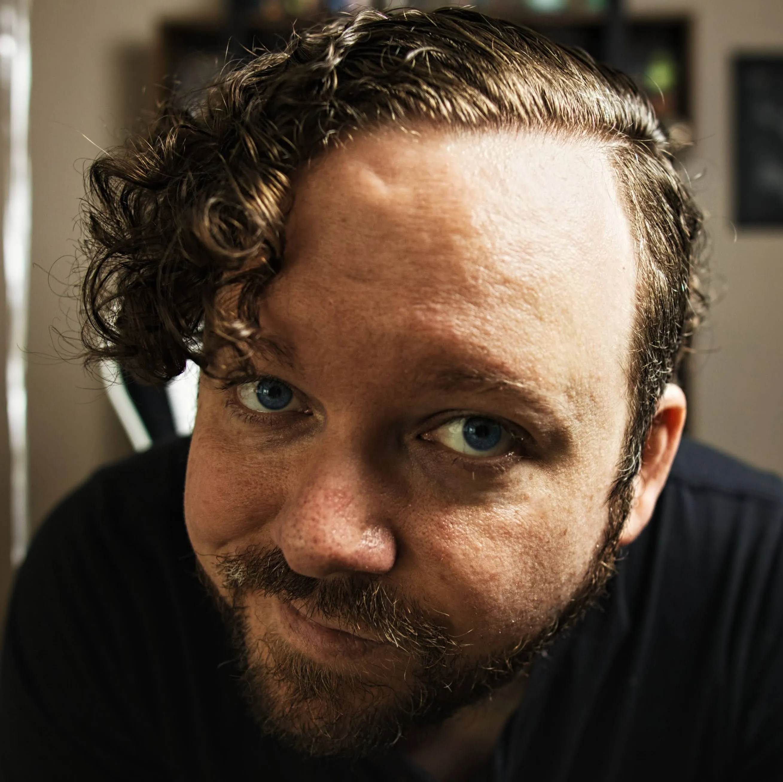 Eric Teichmiller — a bearded man with glasses, looking toward the camera in warm natural light.
